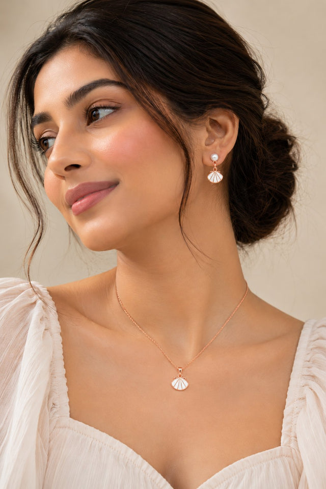 Model wearing the Shell Fan white enamel pendant and drop earrings in rose gold-plated finish