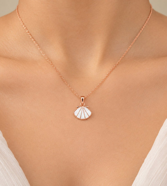 Close-up of the white enamel shell fan pendant worn on the neck