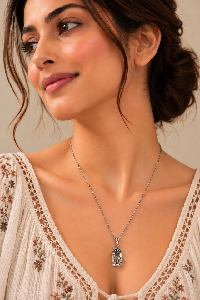 Model wearing Oxidised Silver Birdcage Pendant