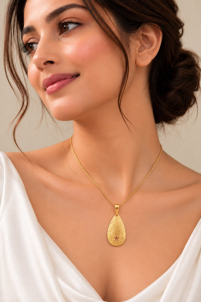 Model wearing Textured Gold Star Teardrop Pendant